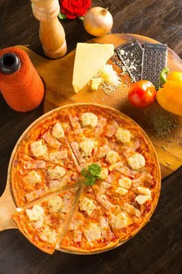 a pizza sitting on top of a wooden table at Westgate Residence Hotel in Ban Bang Kho