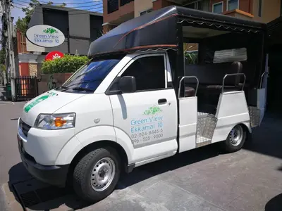 a white truck with a green view electric vehicle at Greenview Ekkamai10 Suite in Bangkok
