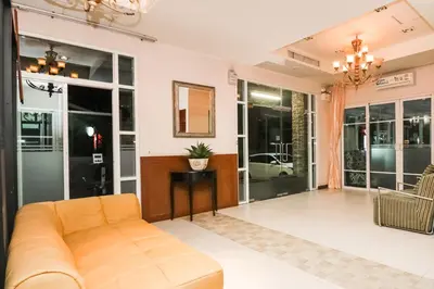 a living room with a couch and some windows at Greenview Ekkamai10 Suite in Bangkok
