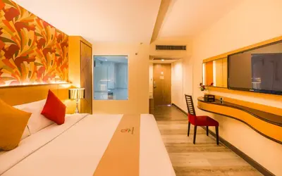 a bedroom with a bed and a desk and a tv at Grand Lord Boutique Hotel -Srinakarin in Bangna