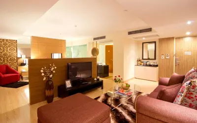a living room with a couch and a tv at Grand Lord Boutique Hotel -Srinakarin in Bangna