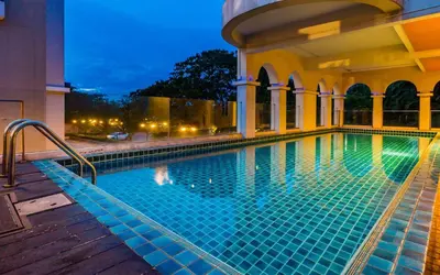 a swimming pool at a hotel at night at Grand Lord Boutique Hotel -Srinakarin in Bangna