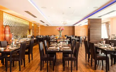 a restaurant with tables and chairs in a room at Grand Lord Boutique Hotel -Srinakarin in Bangna