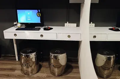 a desk with a computer and two drums underneath it at Four Sisters Homestay in Bangkok