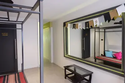 a mirror on a wall with a table in a room at Four Sisters Homestay in Bangkok