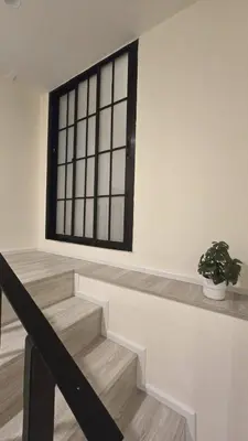 a staircase with a window and a potted plant at Wang Lang Hostel in Bangkok