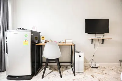a kitchen with a desk and a refrigerator and a chair at Wang Lang Hostel in Bangkok