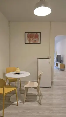 a table and chairs and a table and a refrigerator at Wang Lang Hostel in Bangkok