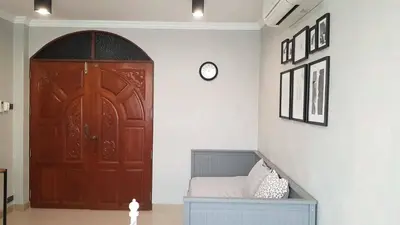 a room with a door and a bed and a clock at Wang Lang Hostel in Bangkok