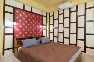 a bedroom with a bed and a red and white wall at Sawatdee Guesthouse the Original in Bangkok