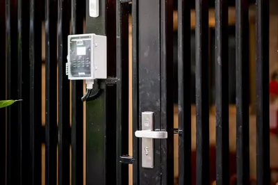 a pay phone is attached to a black fence at Sawatdee Guesthouse the Original in Bangkok