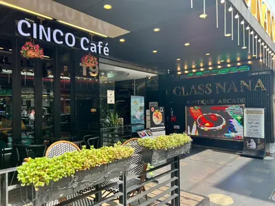a china cafe with chairs and plants in front of it at Fortuna Hotel in Bangkok
