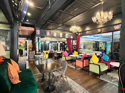a restaurant with colorful furniture and tables and chairs at Fortuna Hotel in Bangkok