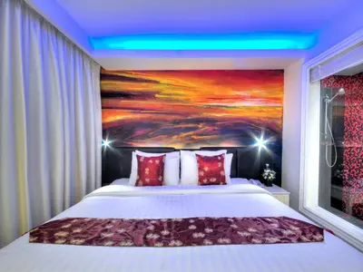 a bedroom with a bed with a painting on the wall at Aspira Skyy Sukhumvit 1 in Bangkok