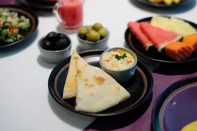 a table with plates of food on a table with dips at Aspira Skyy Sukhumvit 1 in Bangkok