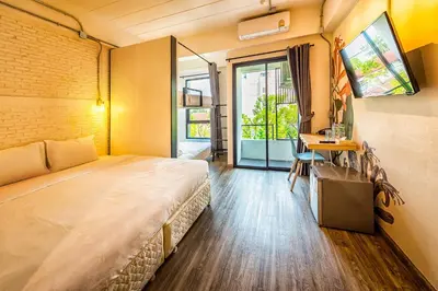 a room with a bed and a desk and a window at Bangkok Oasis Hotel in Bangkok