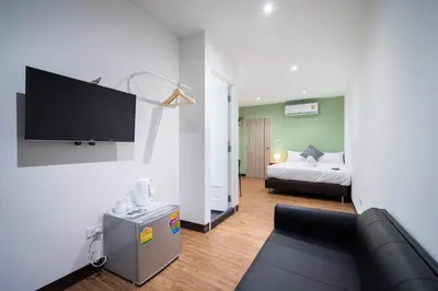 a living room with a couch and a tv on a wall at Resort V - MRT Huai Khwang in Bangkok