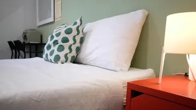 a bedroom with a bed with a pillow and a table at Resort V - MRT Huai Khwang in Bangkok