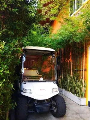 a white golf cart parked next to a fence at Resort V - MRT Huai Khwang in Bangkok