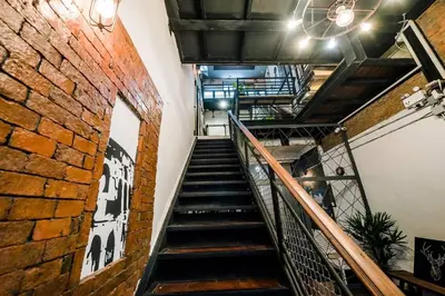 a staircase in a building with a brick wall at Zeds Hostel Bangkok in Bangkok