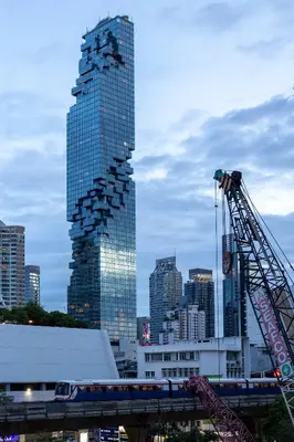 a tall building in a city with a crane at Nantra Silom in Bangkok