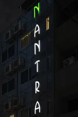 a tall building with a sign that readsatalonto at Nantra Silom in Bangkok