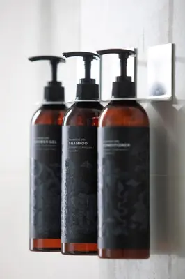 a group of three shampoo bottles sitting on a shelf at Nantra Silom in Bangkok