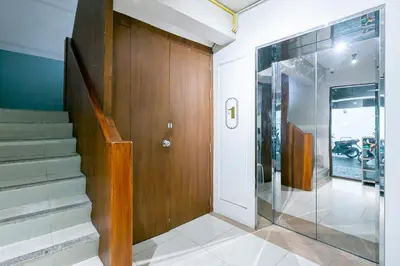 a hallway with a wooden door and a glass entryway at A Room Bangkok Sathorn in Bangkok