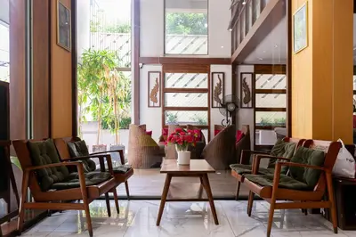 a lobby with chairs and a table and windows at A Room Bangkok Sathorn in Bangkok