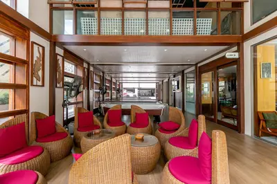 a room with wicker chairs and a table with pink seats at A Room Bangkok Sathorn in Bangkok