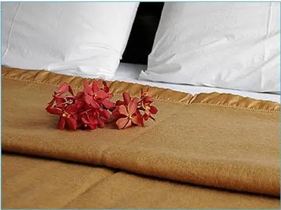 a pile of red flowers sitting on top of a bed at King Royal Garden Inn in Bangkok