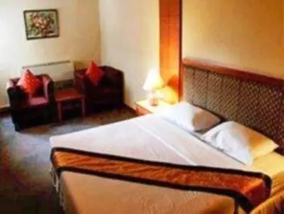 a bedroom with a bed and a couch and a chair at King Royal Garden Inn in Bangkok