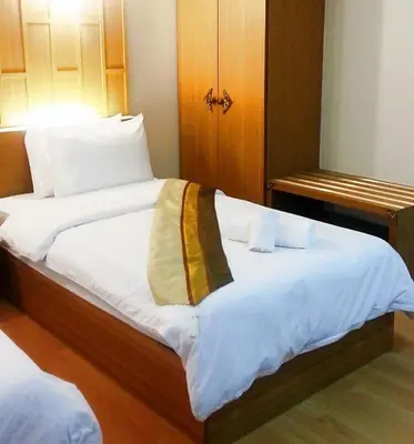 a large bed with white sheets and a blanket on it at King Royal Garden Inn in Bangkok