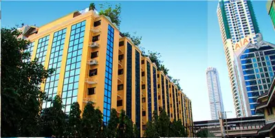 a tall yellow building with windows in a city at King Royal Garden Inn in Bangkok