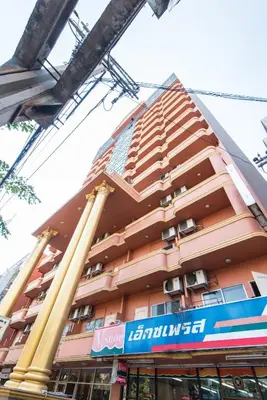 a tall pink building with a sign in front of it at King Royal 2 in Bangkok