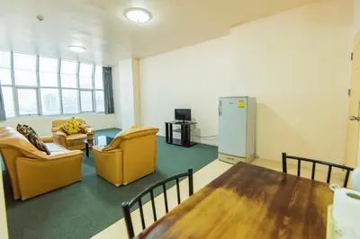 a room with two chairs and a table and a refrigerator at King Royal 2 in Bangkok