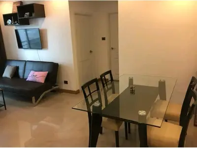 a living room with a glass table and a couch at Gsuite Glamorous Apartment in Bangkok