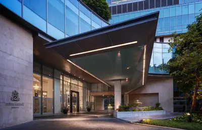 an external view of a building with a glass facade at Oriental Residence Bangkok in Bangkok