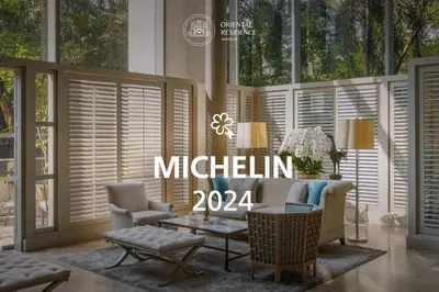 a living room with a couch and chairs and windows at Oriental Residence Bangkok in Bangkok