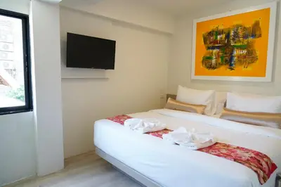 a bedroom with two beds and a flat screen tv at Sawasdee House in Bangkok