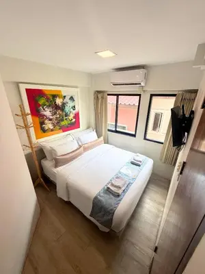 a bedroom with a large white bed in a room at Sawasdee House in Bangkok