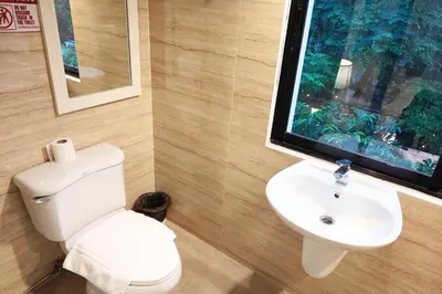 a bathroom with a toilet and a sink at Sawasdee House in Bangkok
