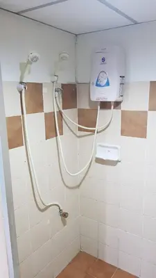 a shower in a bathroom with a white tiled wall at The Montana Lodge-Sathorn in Bangkok