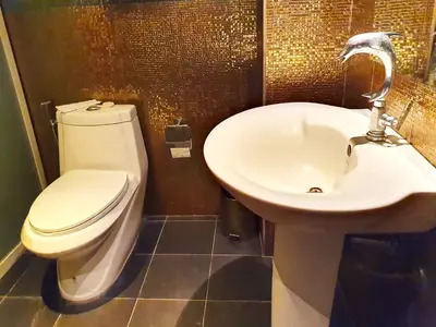 a bathroom with a white toilet and a sink at The Montana Lodge-Sathorn in Bangkok