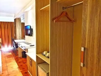 a room with a kitchen and a closet with a tv at The Montana Lodge-Sathorn in Bangkok
