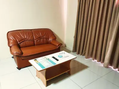 a brown leather couch in a living room with a coffee table at The Montana Lodge-Sathorn in Bangkok