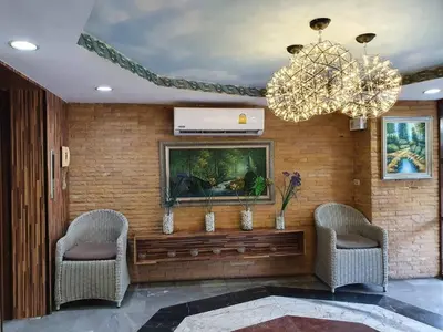 a living room with two chairs and a television and a chandelier at The Montana Lodge-Sathorn in Bangkok