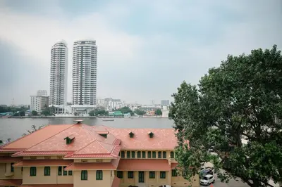 a building with a red roof in front of a city at Casa Picasso Near Chabad House in Bangkok