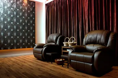 a living room with two leather chairs and curtains at Siam Swana in Bangkok