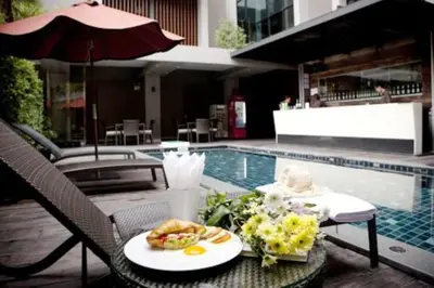a table with a plate of food next to a pool at Siam Swana in Bangkok
